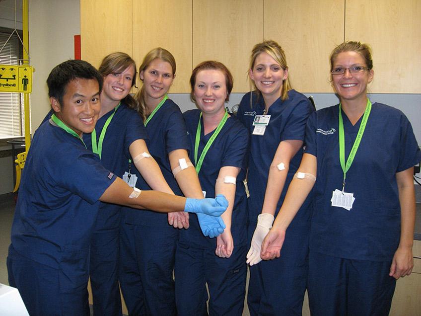Students displaying successful phlebotomy sticks.