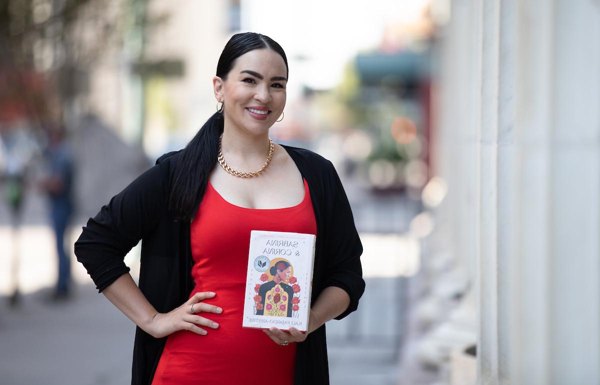 Author Kali Farjardo-Anstine holding her book Sabrina & Corina