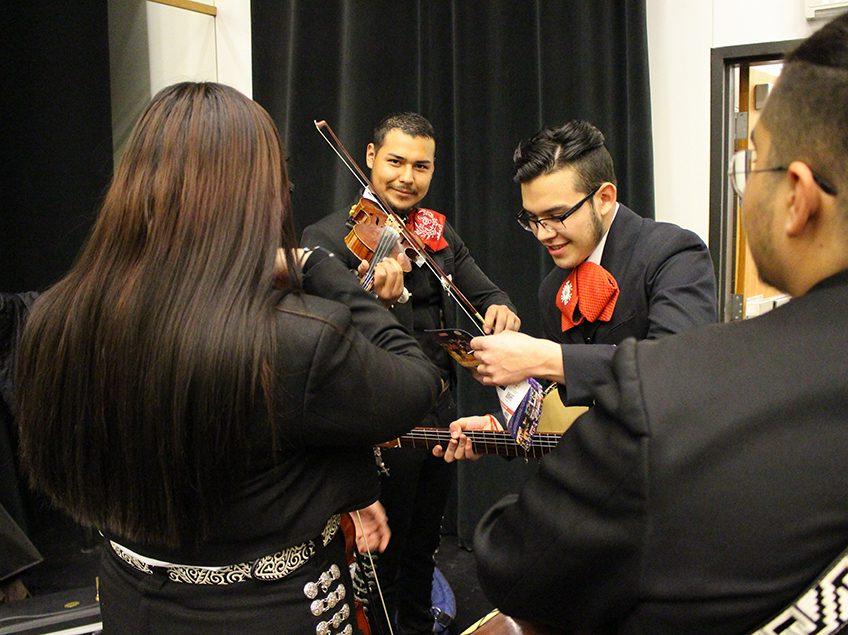 mariachi perfomers backstage practicing instruments